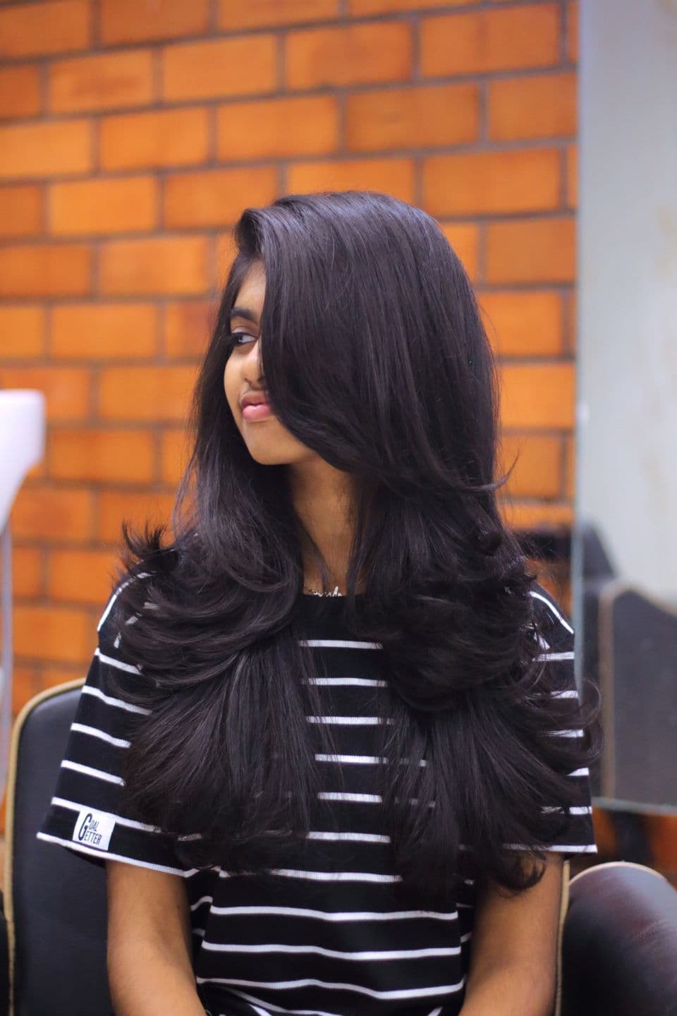 South Asian model with long layered hair in a salon